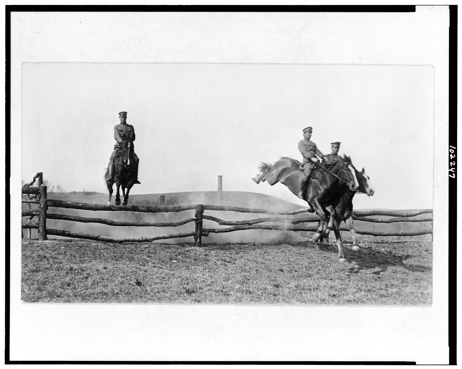 [Three U.S. Army cavalrymen on horses jumping over barrier], [191-?] — historic photograph