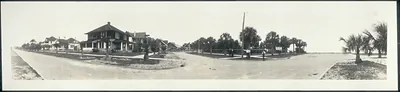 Panoramic street scene with bungalows and palm trees