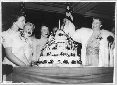 [Eleanor Roosevelt cutting birthday cake, with Lana Turner and Deana Durbin on her right]