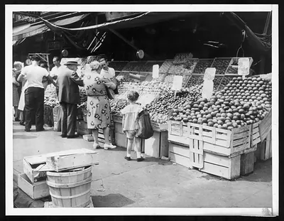Customers purchasing fruits and vegetables at a market stall