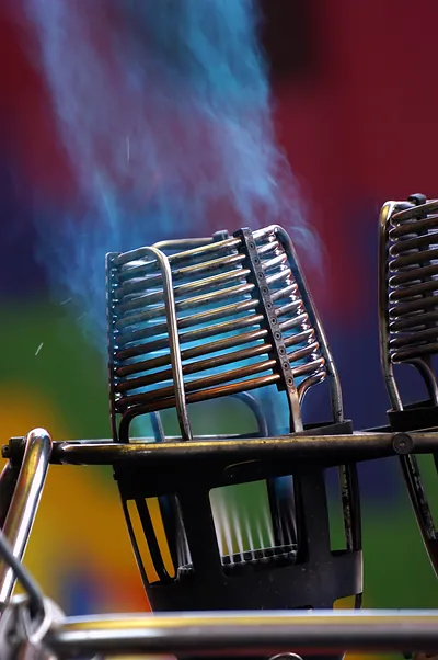 Chrome grille with blue flame against colourful blurred background