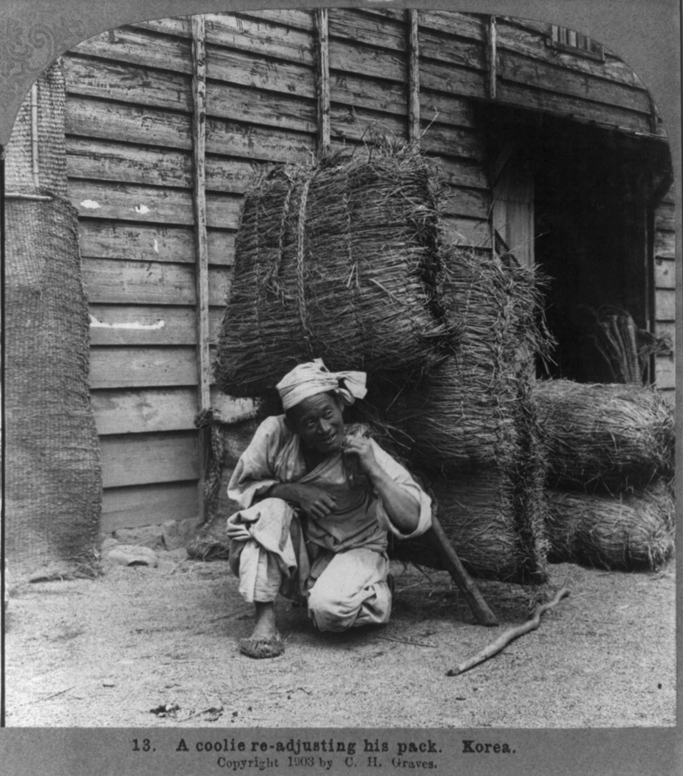 A coolie re-adjusting his pack, Korea, c1903. — historic photograph