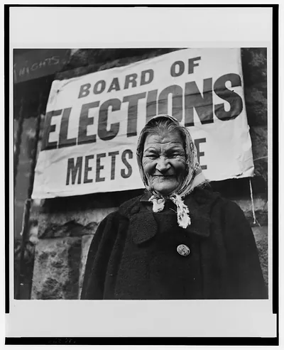 [Woman wearing a Roosevelt campaign button standing before a banner, Board of elections meets [her]e"]"