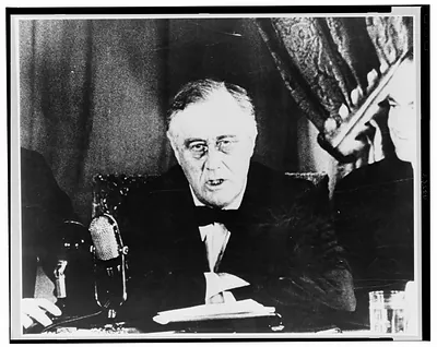 [Franklin Delano Roosevelt, head and shoulders, facing front, speaking before microphone]