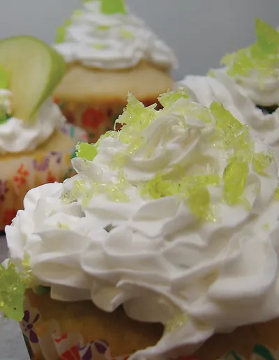Cupcakes with whipped frosting and green apple garnish