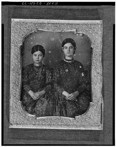 [Group portrait of two unidentified girls, three-quarter length, seated, facing front]
