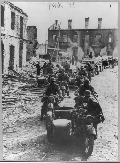 [German motorized detachment riding through wreckage of Polish town during Blitzkrieg of Sept. 1939]