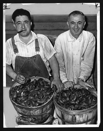 Two men with baskets of mussels, black and white photograph