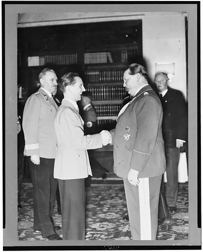 [Hermann Göring and Joseph Goebbels, three-quarter length portrait, facing each other, shaking hands]