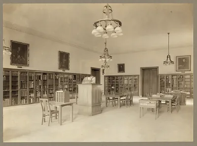 Library reading room with bookcases, tables and chandeliers