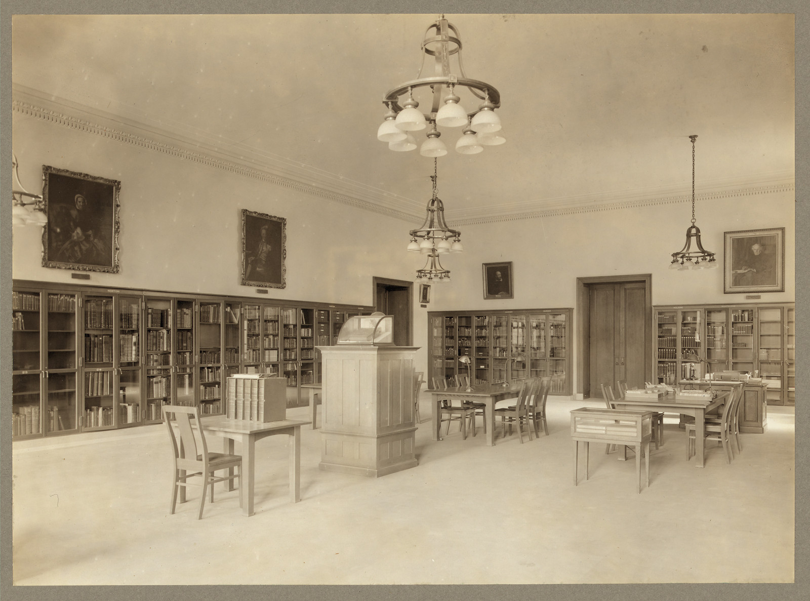 Library reading room with bookcases, tables and chandeliers — historic image