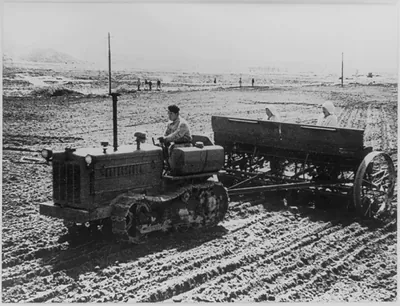 Sowing seeds [with a caterpillar and planter], N. Korea