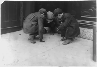 [Mill boys pitching pennies on the Main St. in the afternoon. One said he sweeps. One said I was workin' but got canned 'cause I was not fast enough." The other was "jest hangin' around."] Location: Fall River Massachusetts. / Lewis W. Hine."