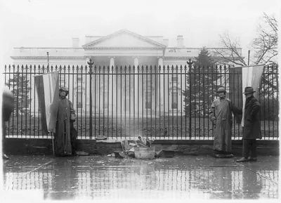 [Two suffragettes and bonfire at front gate, White House, Washington, D.C.]