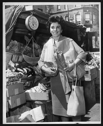 Smiling woman shopping at a produce market stall