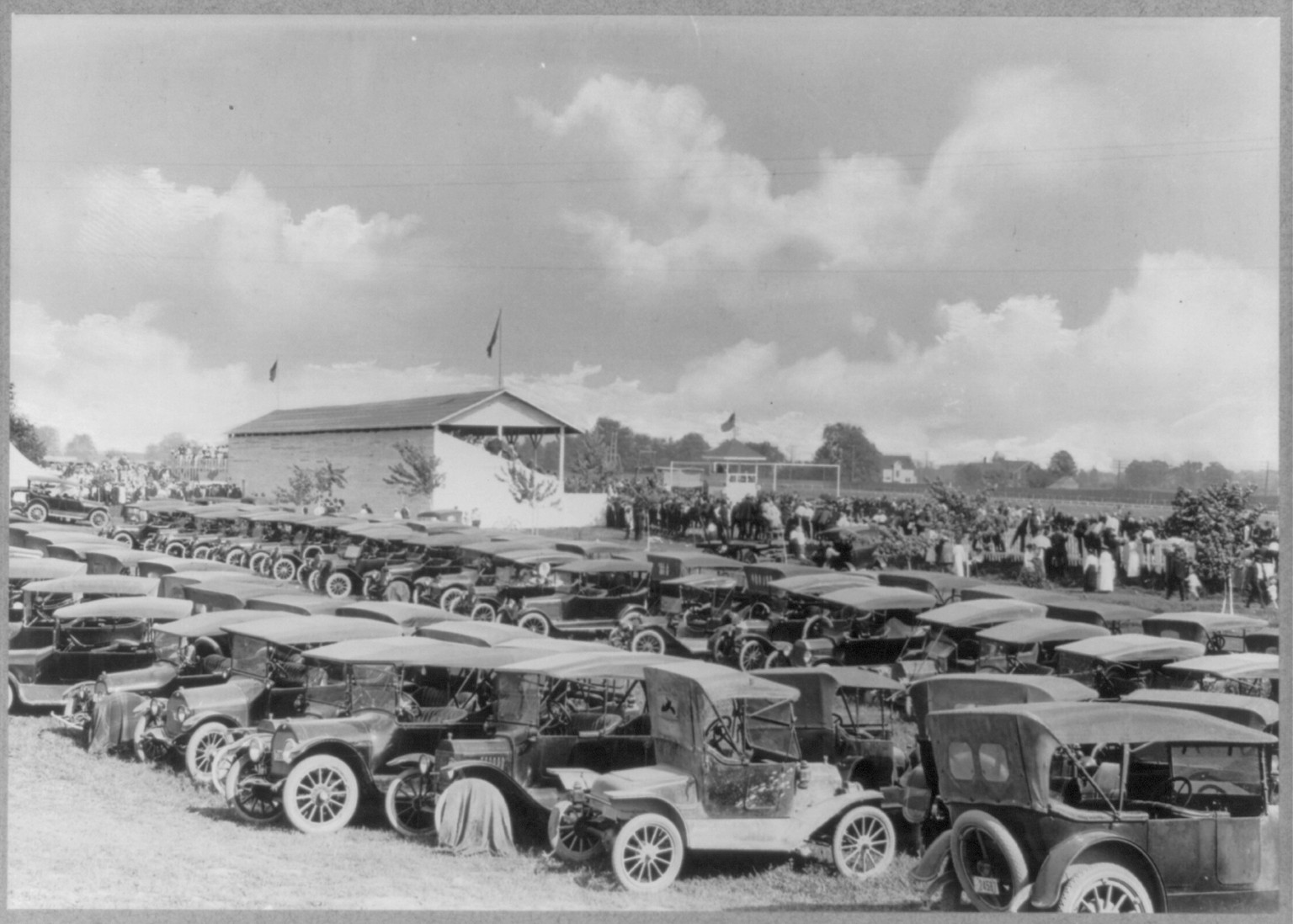 Early model automobiles in fair grounds parking lot, Owosso, Michigan, [ca. 1920] — historic photograph