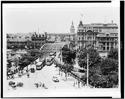 [Bird's-eye view of Shanghai, China, showing streetcars crossing bridge, and buildings in background]