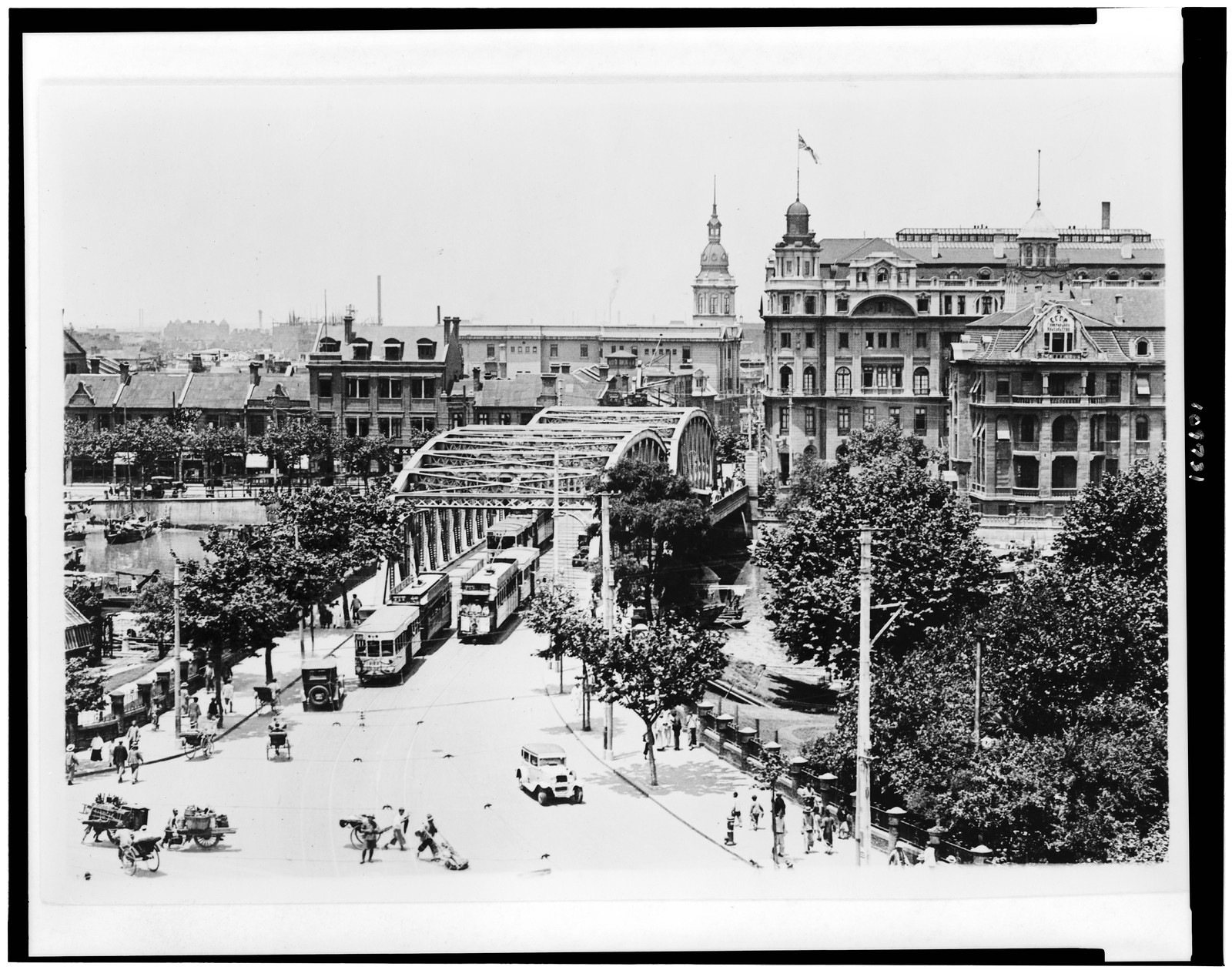 [Bird's-eye view of Shanghai, China, showing streetcars crossing bridge, and buildings in background], [ca. 1935] — historic photograph