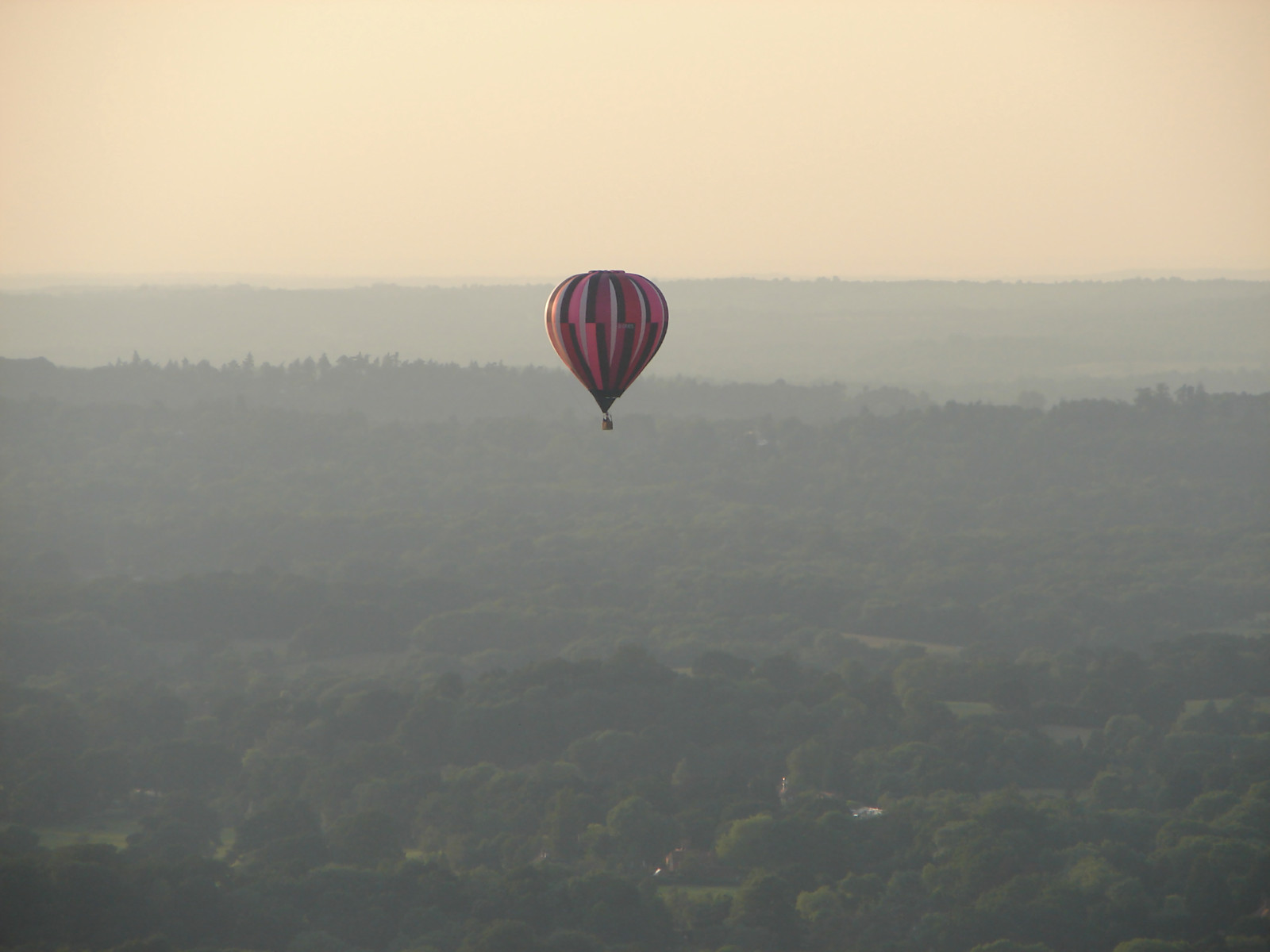 Hot air balloon over hazy countryside at dusk — historic image