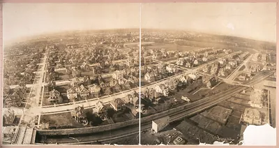 Aerial panorama of residential streets beside a railway cut