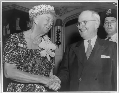 Smiling woman with name badge shaking hands with man