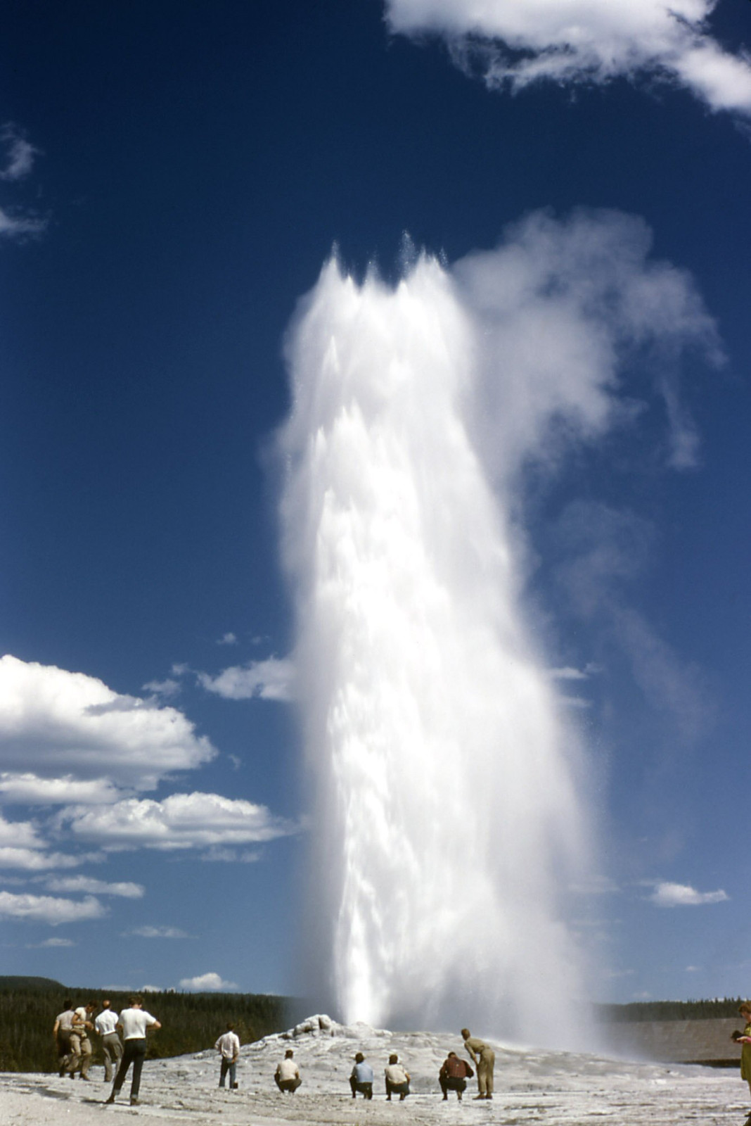 Geyser eruption with people watching on geyser cone — historic image