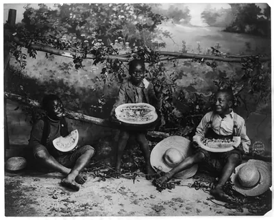 [3 African American boys eating watermelon]