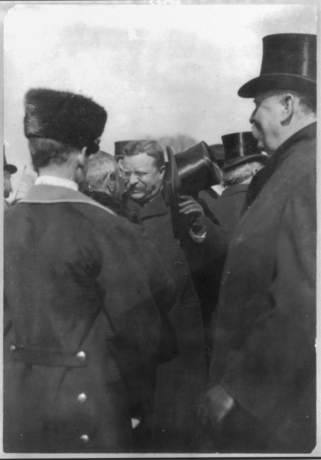 [Theodore Roosevelt, Pres. U.S. receiving congratulations from diplomats; raising hat in crowd] — historic photograph