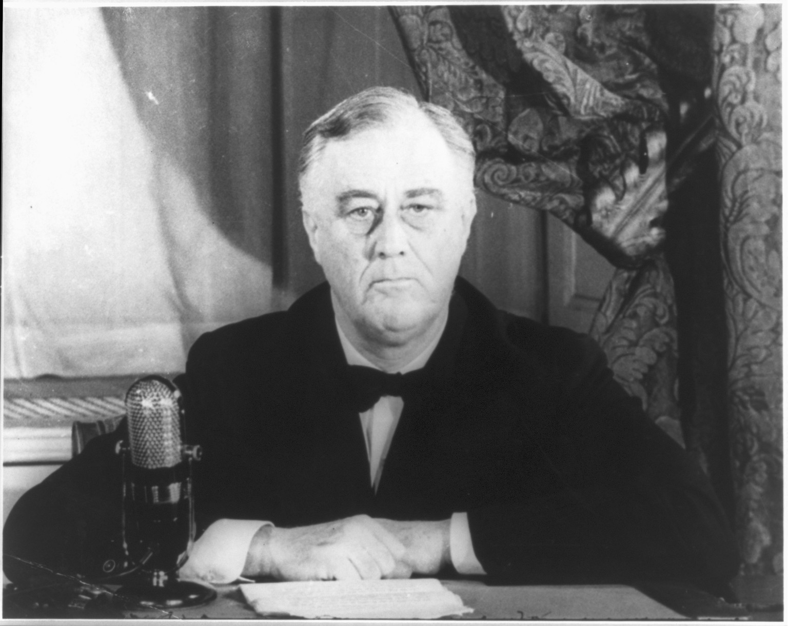 [Franklin Delano Roosevelt, head and shoulders, seated, by microphone] — historic photograph