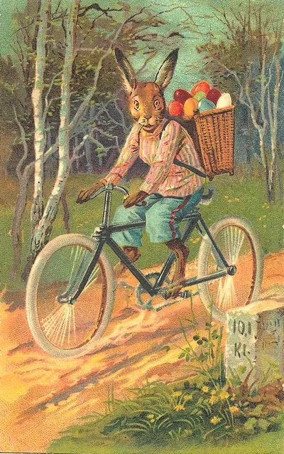Anthropomorphic rabbit riding bicycle with Easter eggs in basket
