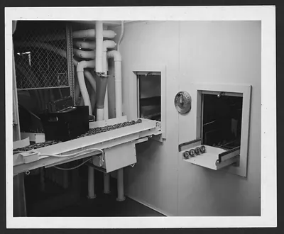 Roller conveyor and pass-through hatches beside white pipes