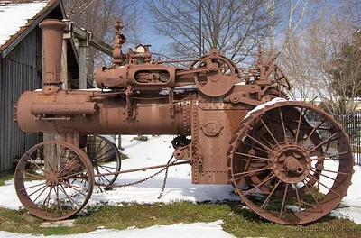Rusty antique steam tractor with spoked iron wheels