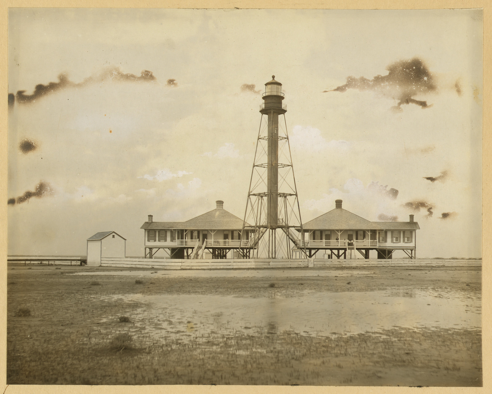 Lattice-tower lighthouse with keepers' houses, sepia photograph — historic photograph
