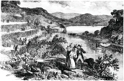 Couple on rocky ledge overlooking vineyards and steamboats on a river
