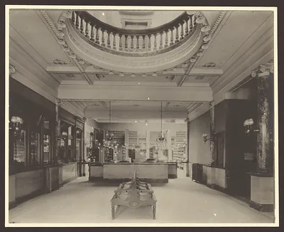 Library circulation desk beneath a balcony with marble columns