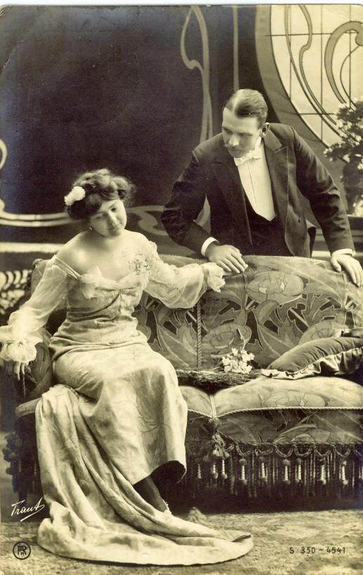 Formal studio portrait of a couple on an ornate sofa — historic image