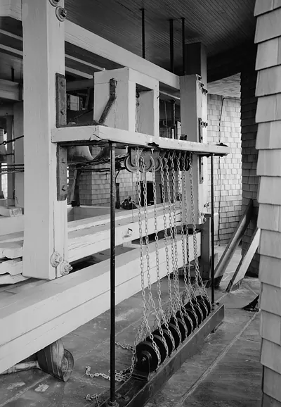 Bell tower interior with chain-driven pulleys and wooden framing