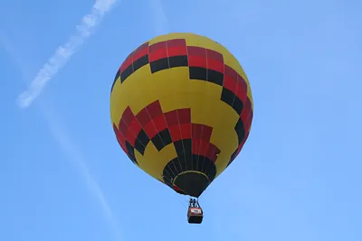 Yellow and red hot air balloon against blue sky