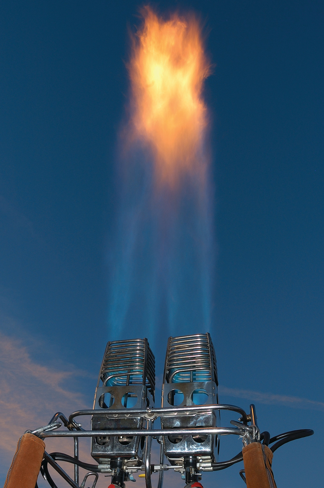 Hot air balloon burner flaming against blue sky — historic image