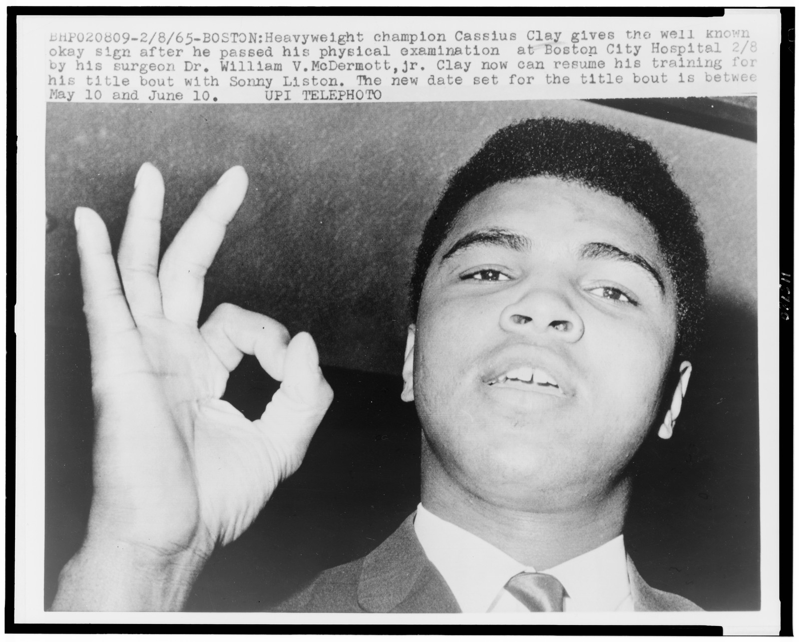 [Muhammad Ali, formerly Cassius Clay, gives OK sign as he leaves Boston City Hospital] — historic photograph