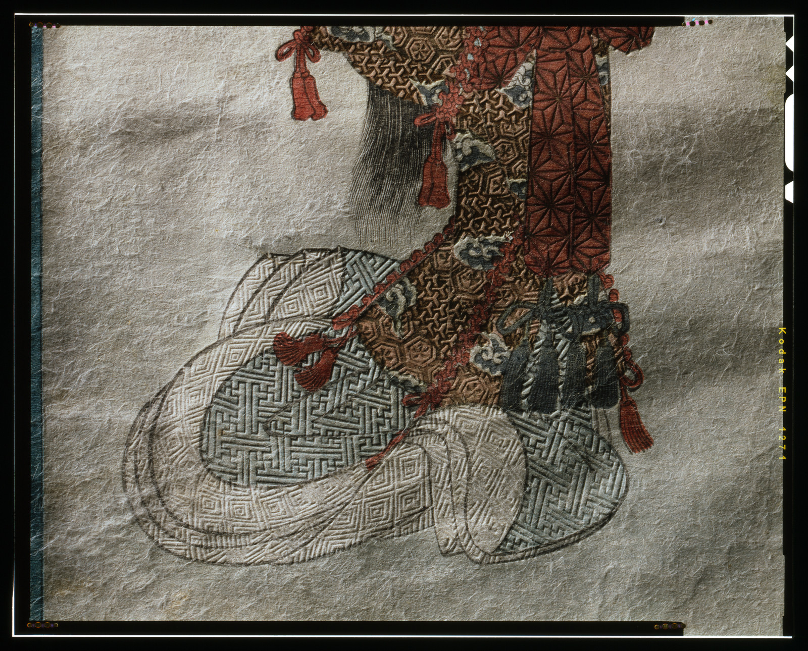 Patterned silk object with red tassels on paper — historic print