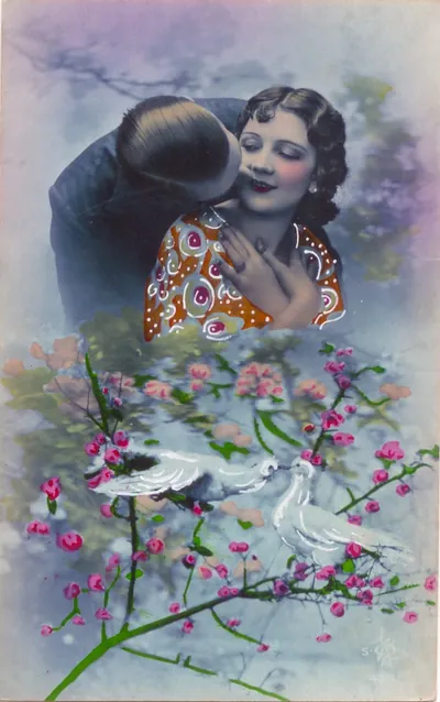 Hand-colored romantic postcard of a couple kissing with doves