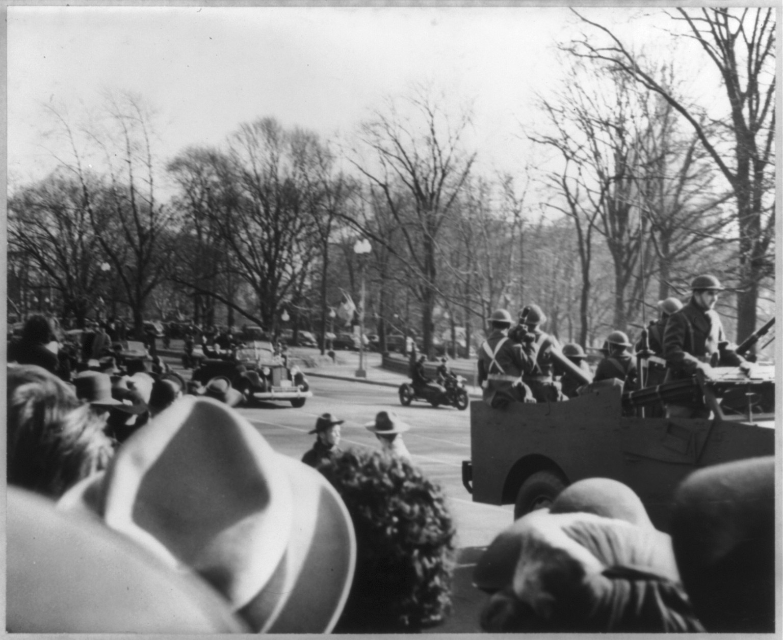 [Franklin D. Roosevelt being escorted in automobile on Inauguration Day. Army troop carrier in front], 1941 Jan. 20. — historic photograph
