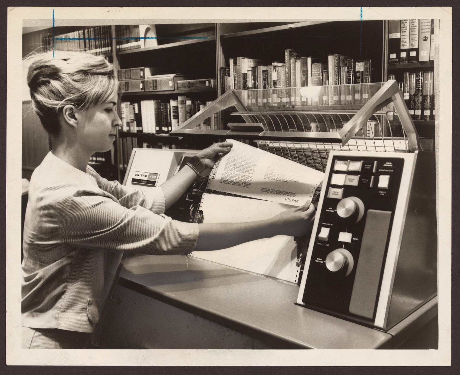 Woman operating a UNIVAC printer in a library — historic print