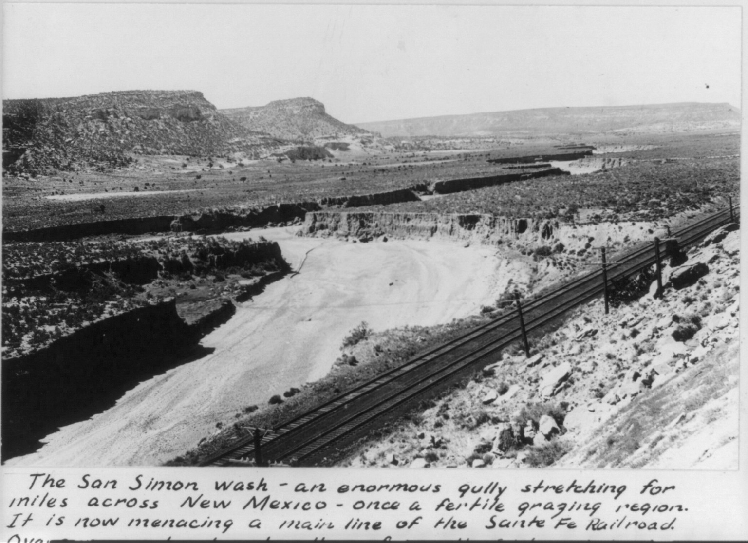 The San Simon wash - an enormous gully, caaused by erosion, stretching for miles across New Mexico [undermining Santa Fe R.R. tracks], [between 1920 and 1930(?)] — historic photograph
