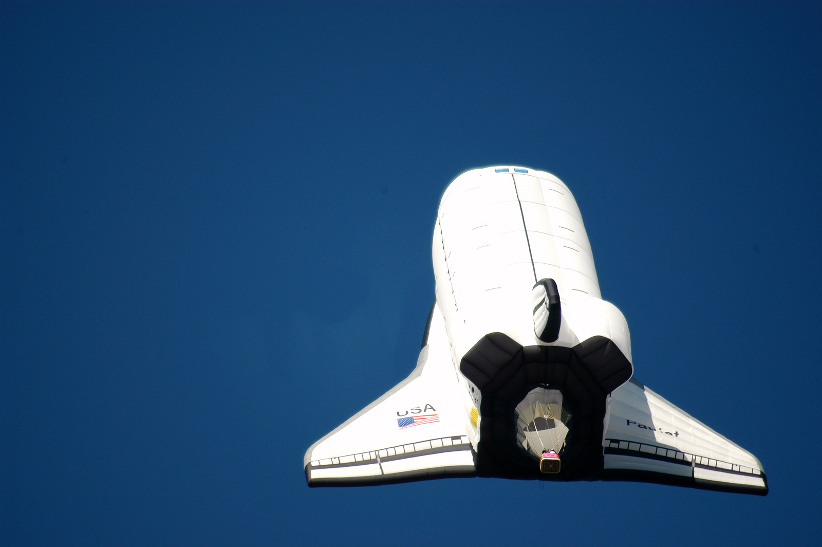 Space shuttle-shaped hot air balloon against blue sky — historic image