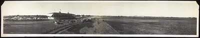 Panoramic view of grandstand and racetrack with horses
