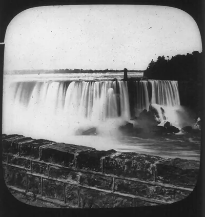 [View of Niagara Falls, with stone wall in foregrd.]