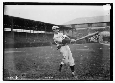 Baseball player Woods mid-swing in a stadium