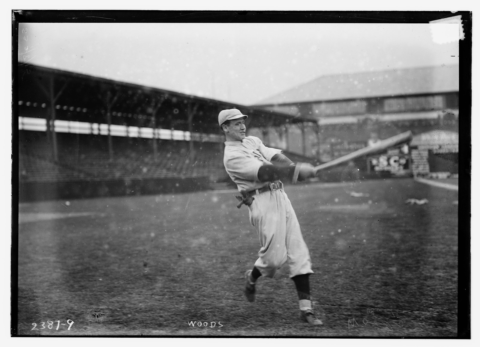Baseball player Woods mid-swing in a stadium — historic image